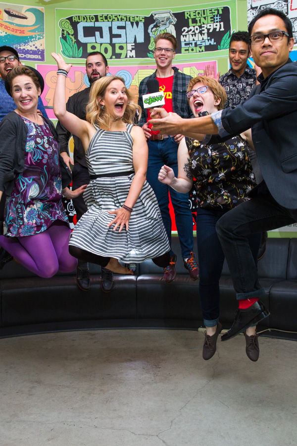 A group of CJSW radio personalities leap into the air.