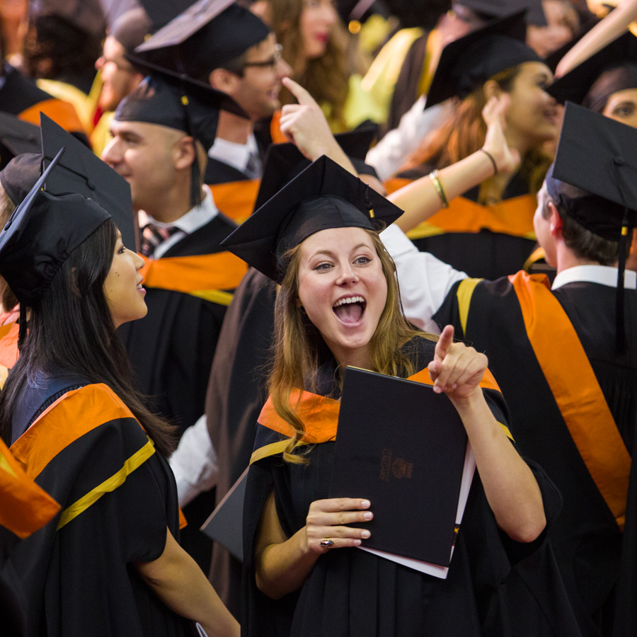 A female engineering student celebrates at graduation.