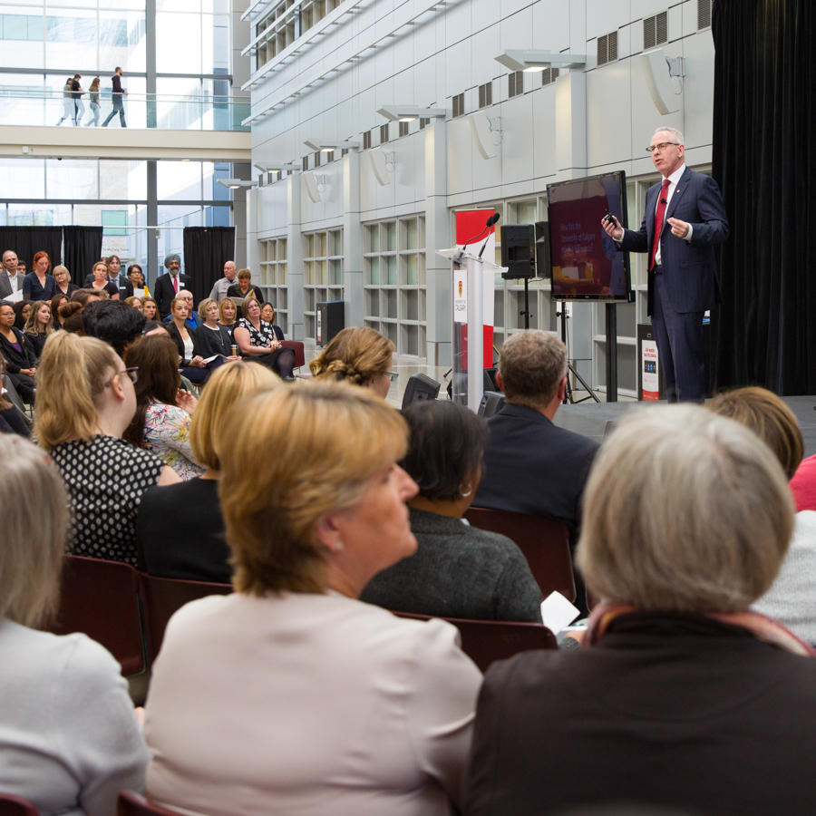A male executive give a speech to a captivated crowd.