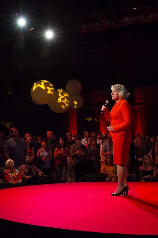 A female executive give a speech to a captivated crowd.