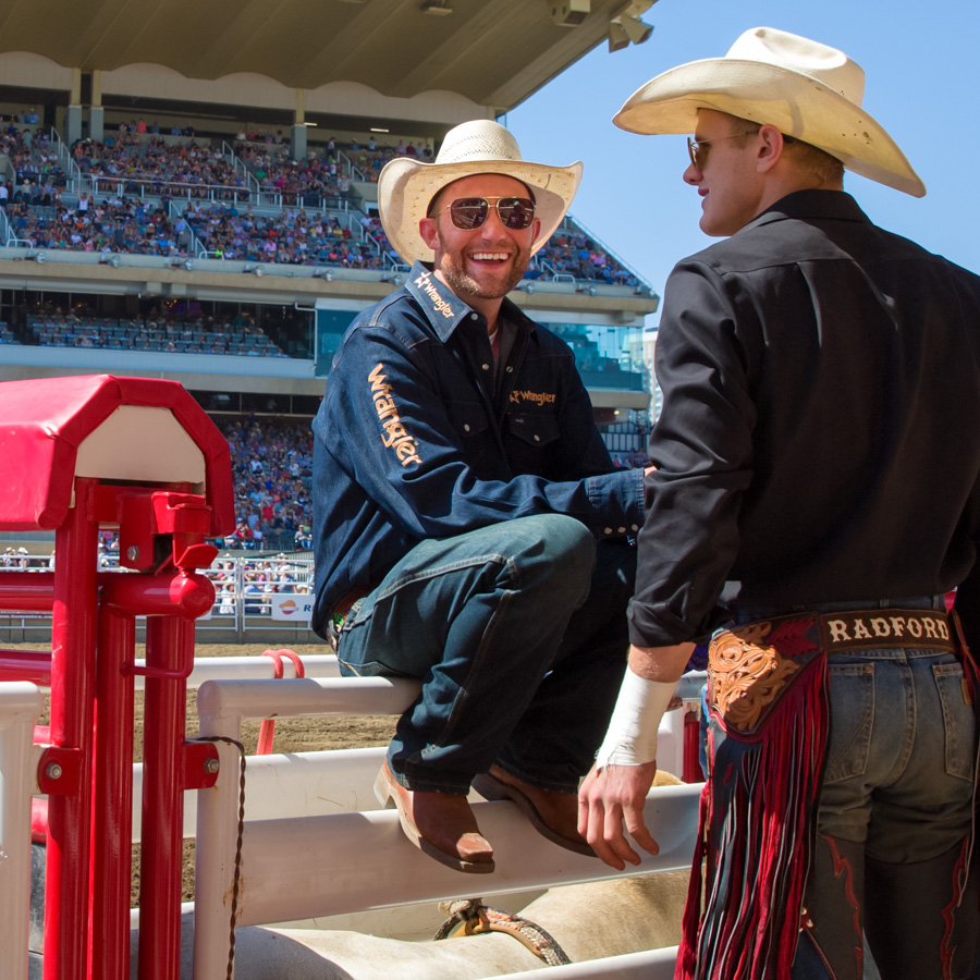 A cowboy at a rodeo smiles at the camera.