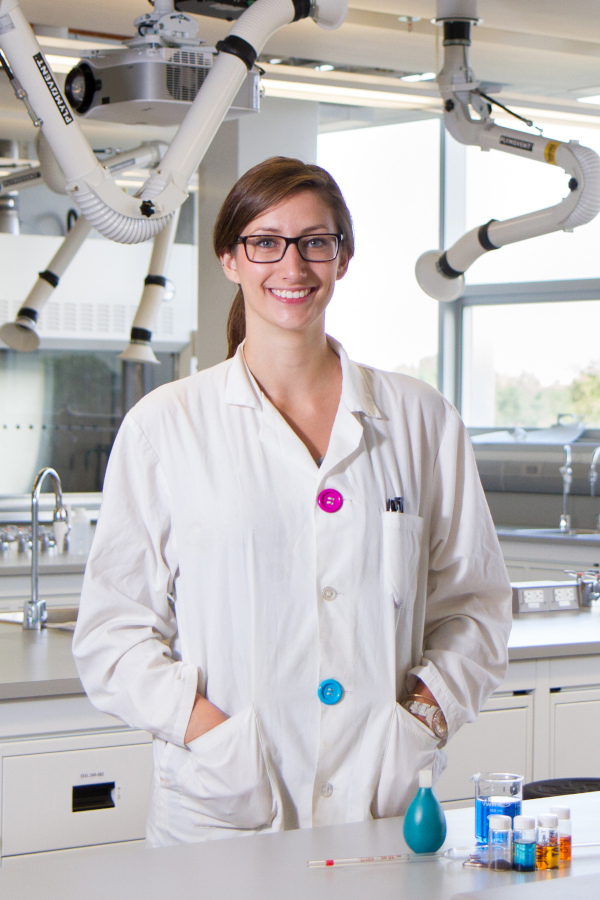 A undergraduate researcher poses in a modern wet lab