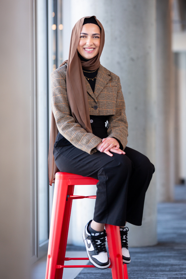 A young woman wearing a traditional hijab, and modern Nikes