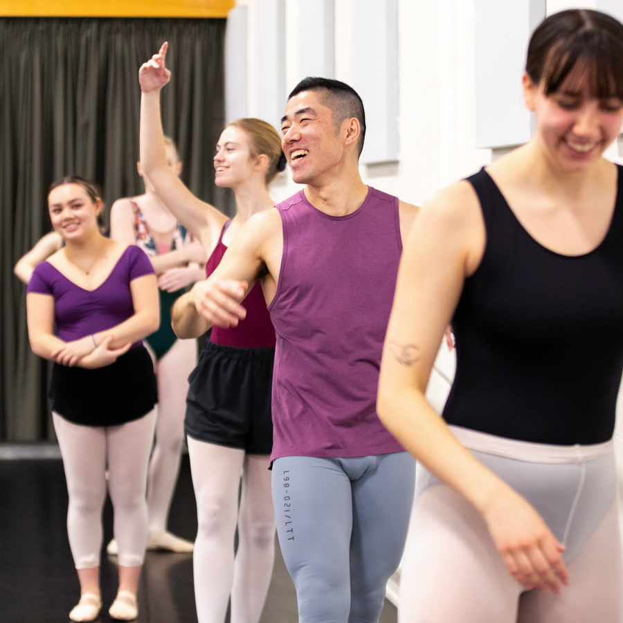 A male ballet student laughs during training.