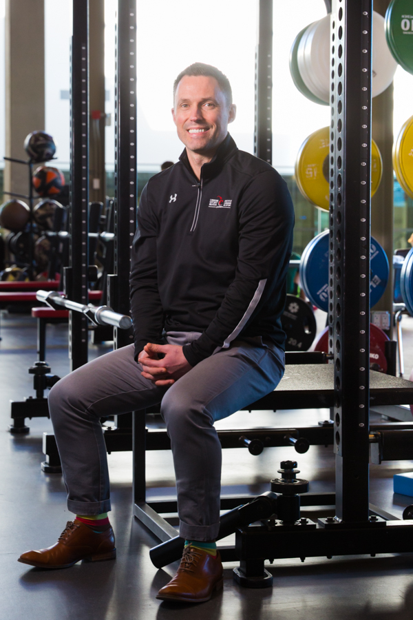 A fitness researcher sits on a weith lifting bench.