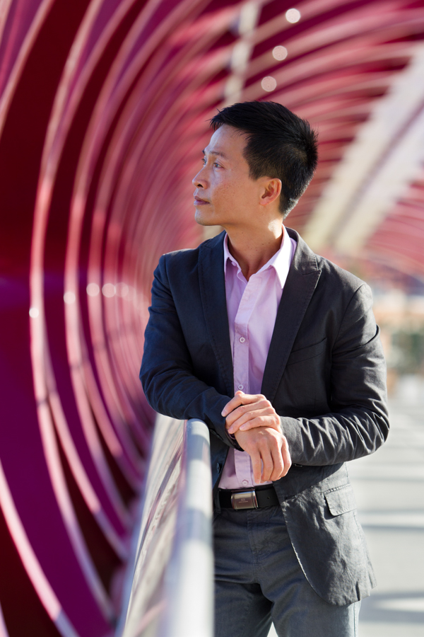 A man on a red bridge stares into the distance.